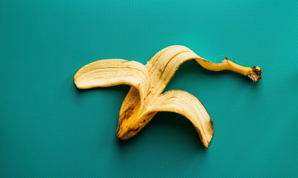 empty banana peel on teal background