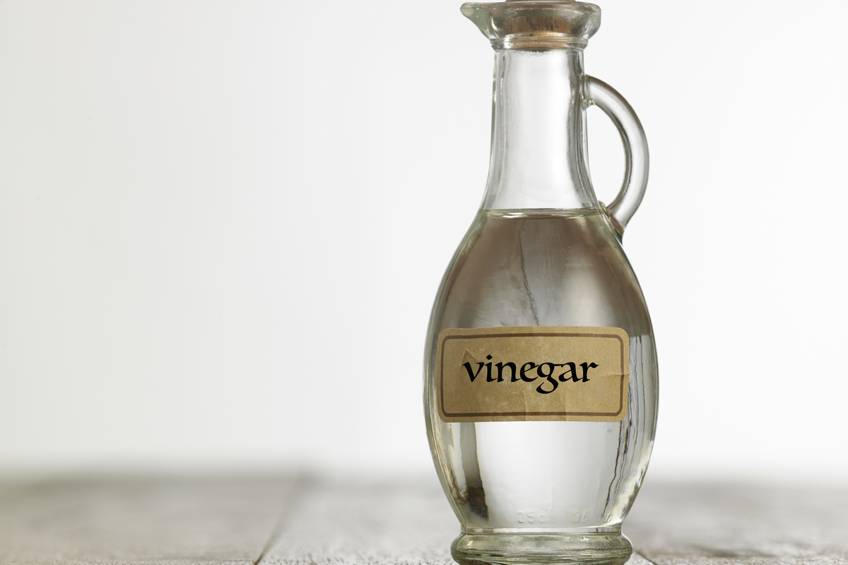 Glass bottle labeled vinegar on table