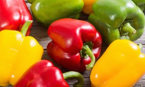 Red, green, and yellow bell peppers on a table